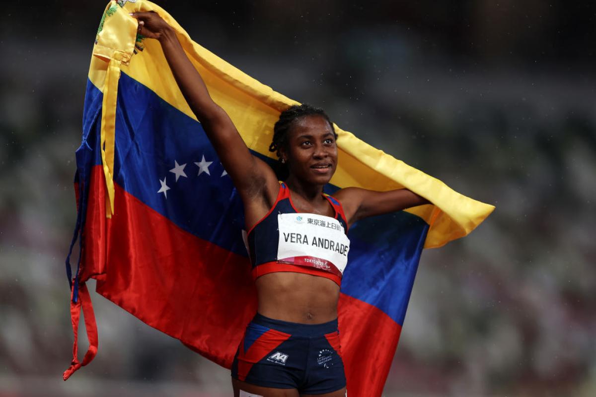 Lisbeli Vera Andrade holds up her country's flag 