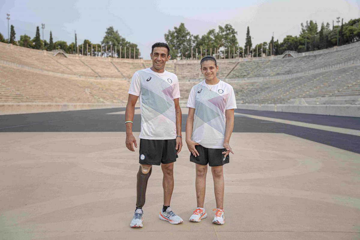 Man and woman stand next to each other with Asics gear