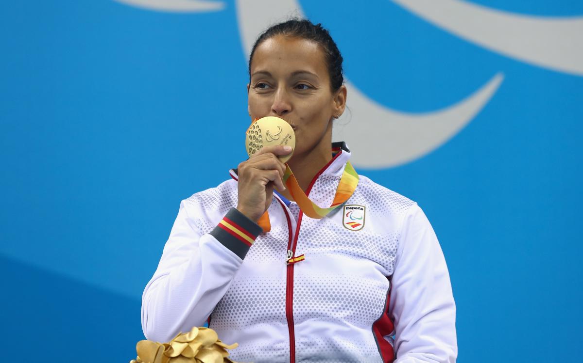 A woman kissing her gold medal