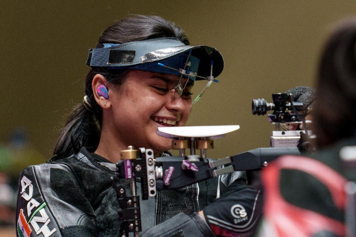 Female Indian shooting athlete smiles