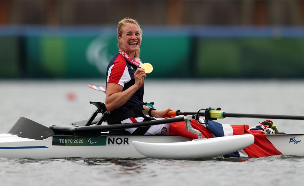 Female rower on her boat celebrates gold medal