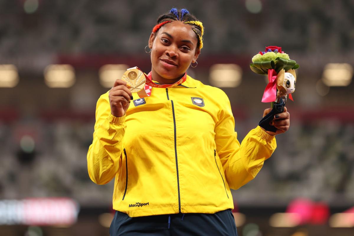 Woman smiles with gold medal around neck