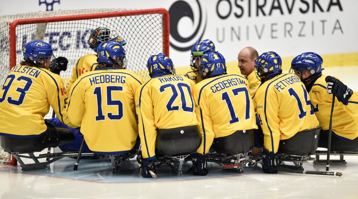 Para ice hockey players making a circle around the goalkeeper before the game