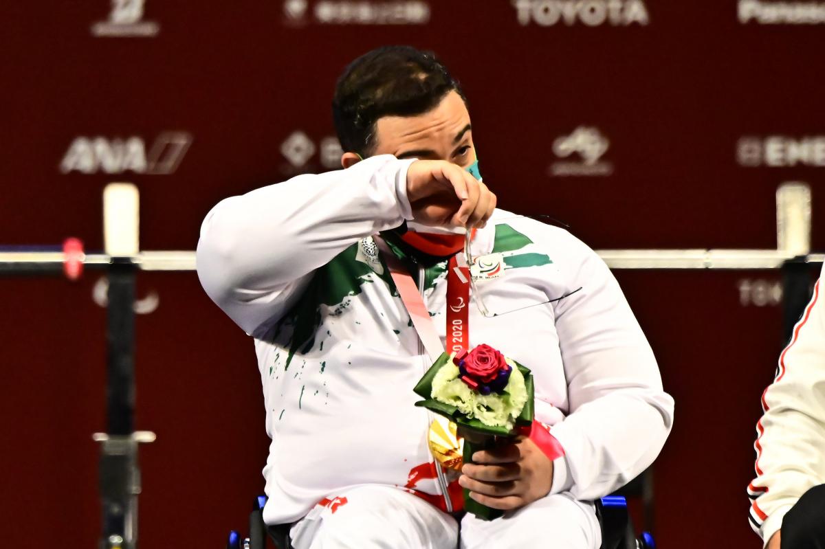 A man crying with a gold medal around his neck