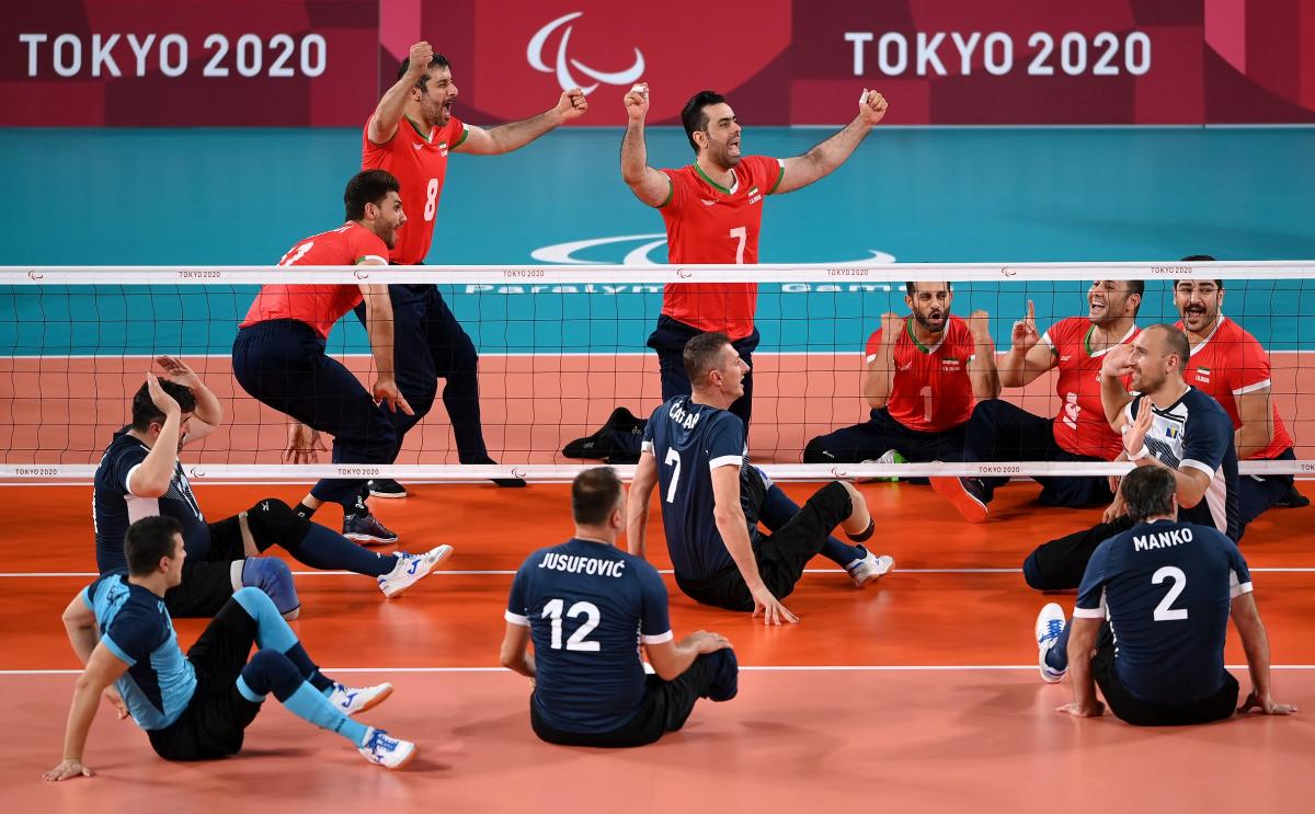 Iranian sitting volleyball team celebrates while Bosnian remains shocked on the other side of the net