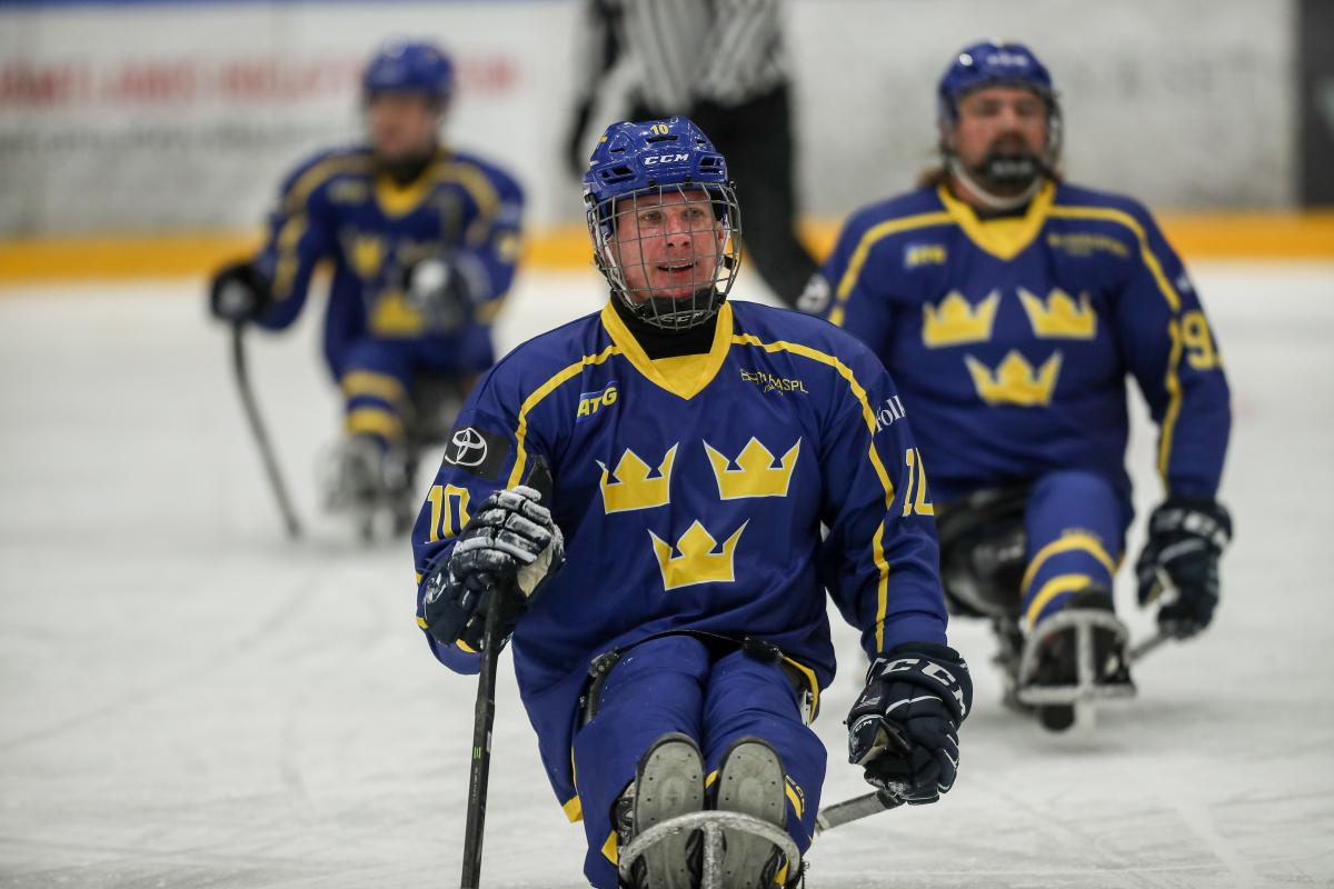 A man skating on a sled and smiling