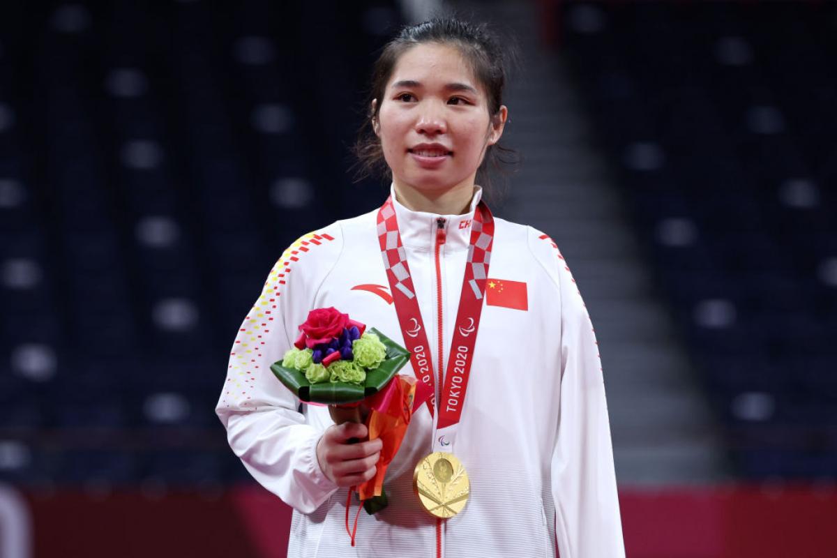 Yang Qiuxia on the podium with gold medal and flowers