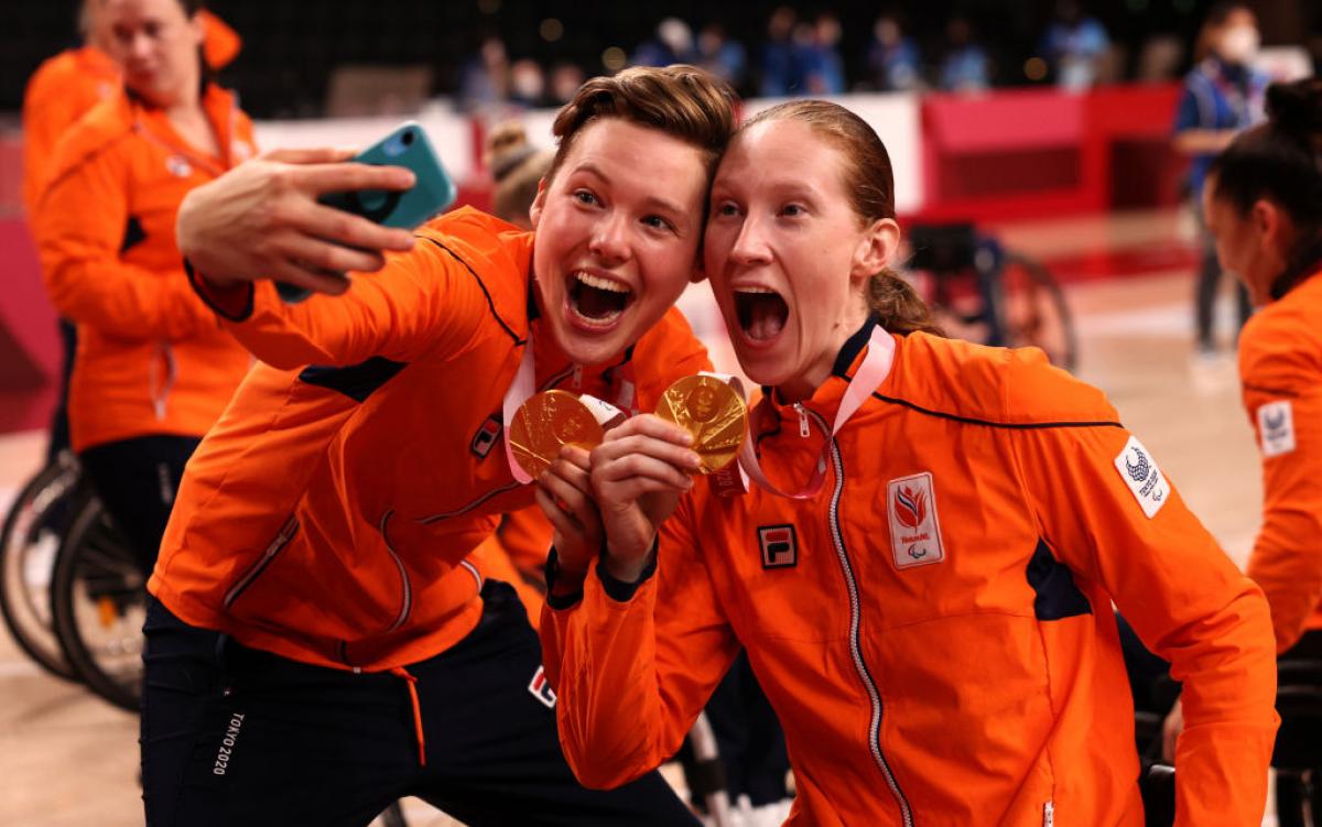 Bo Kramer takes a selfie with Ilse Arts holding their gold medals