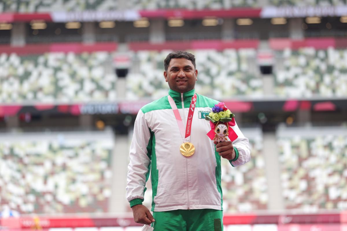 Pakistan's Haider Ali smiles on the podium with the gold medal