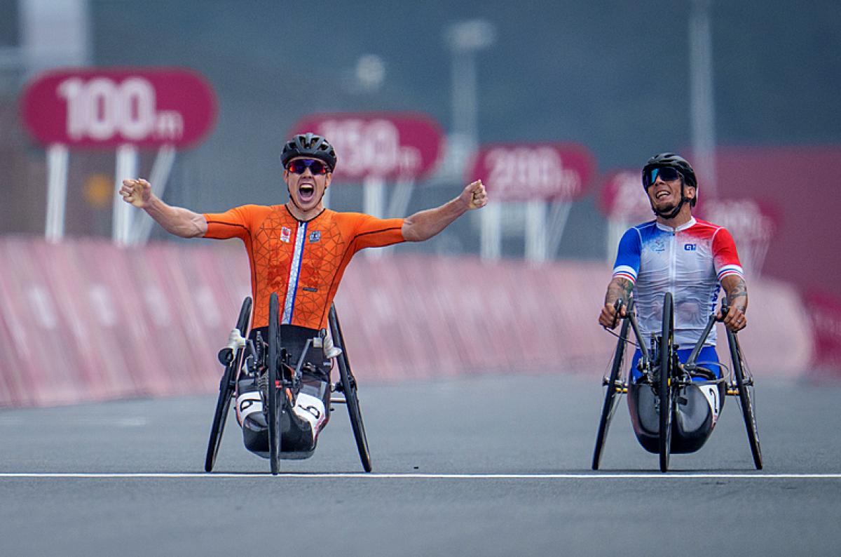 Man celebrates in handbike as opponent disappointed 