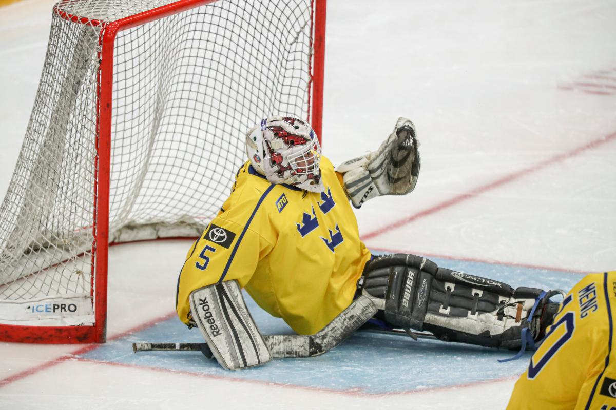 A Para ice hockey goalie holding a puck in his glove