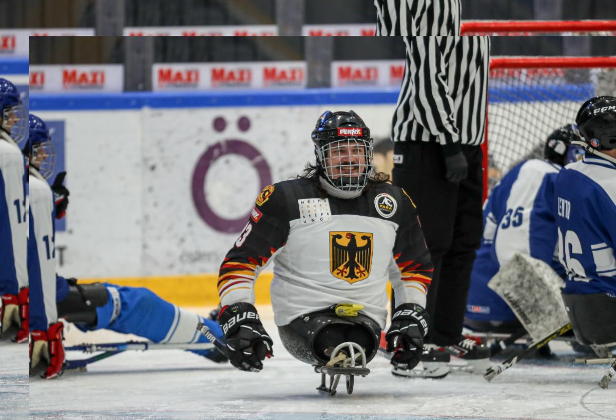 A man on a sled holding two sticks and smiling