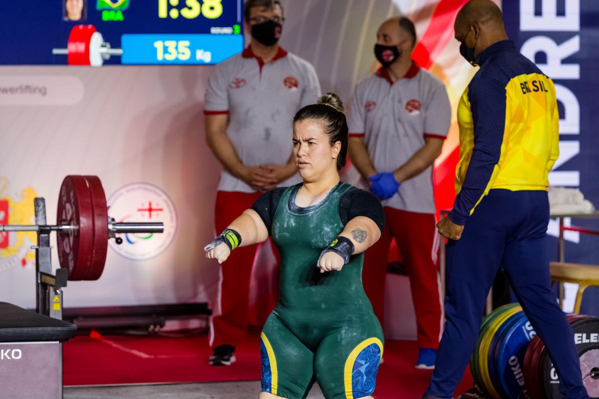 A woman preparing for her lift standing in front of the bar