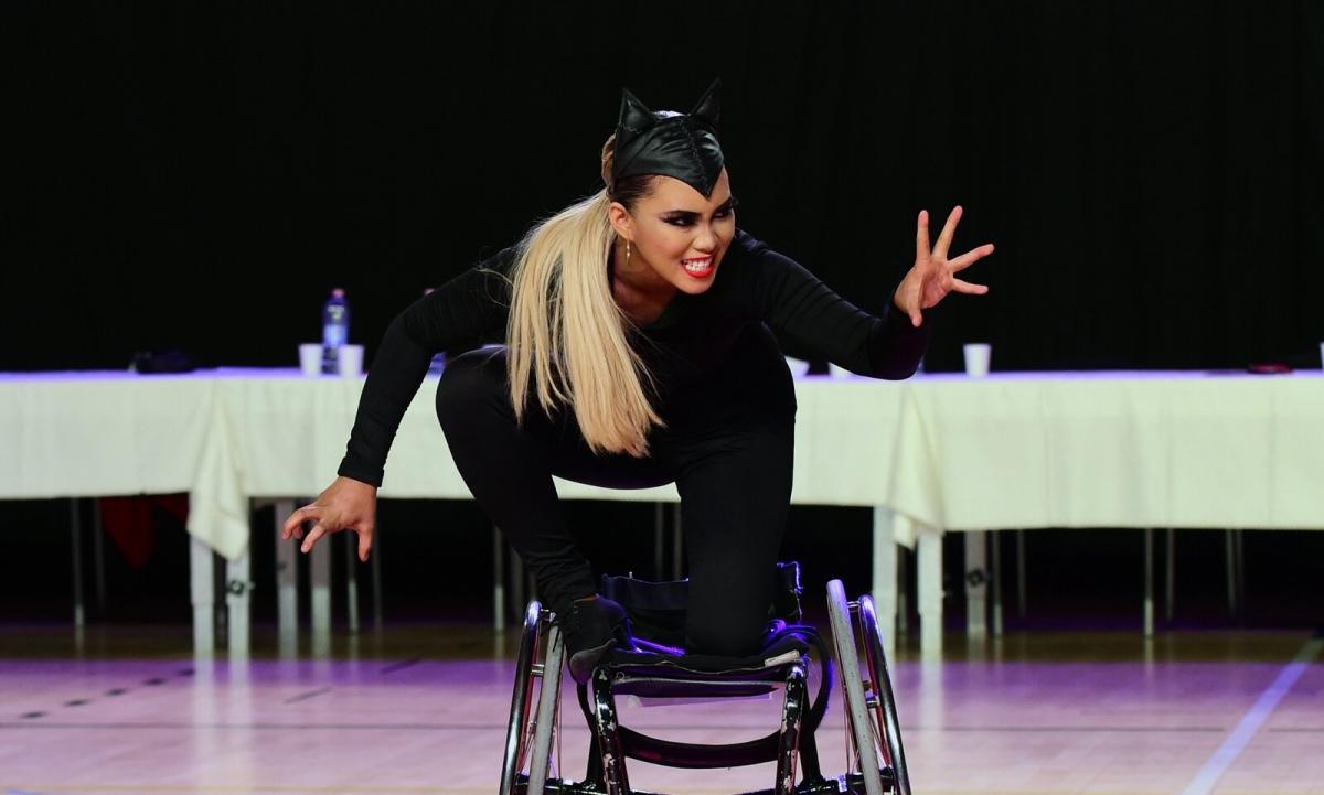 A woman dressed up in a cat performs in a wheelchair during a Para dance sport competition