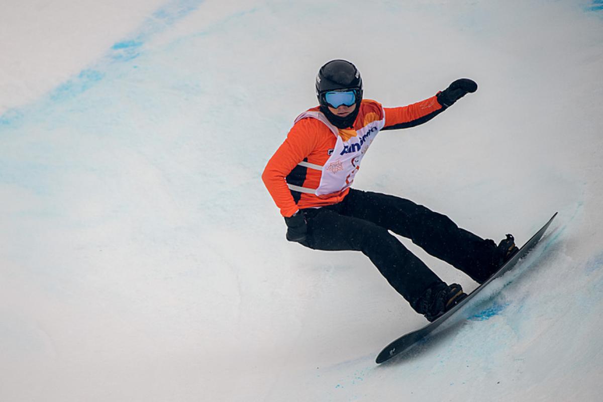 A female Para snowboarder riding with in a competition