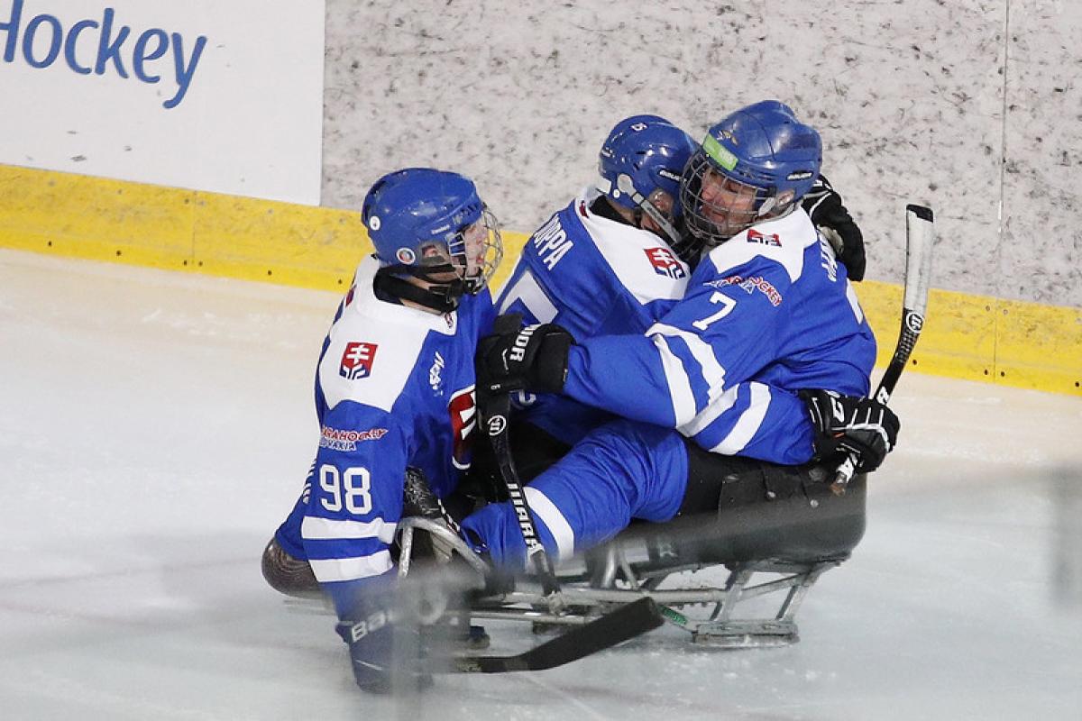 Three Para ice hockey players with Slovakia uniform celebrating