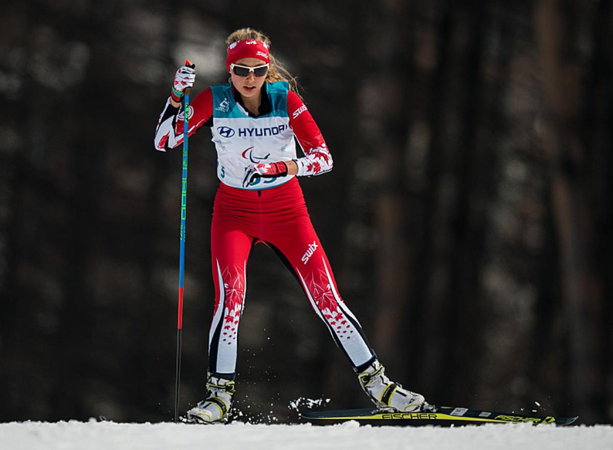 A standing woman competing in Para cross-country skiing