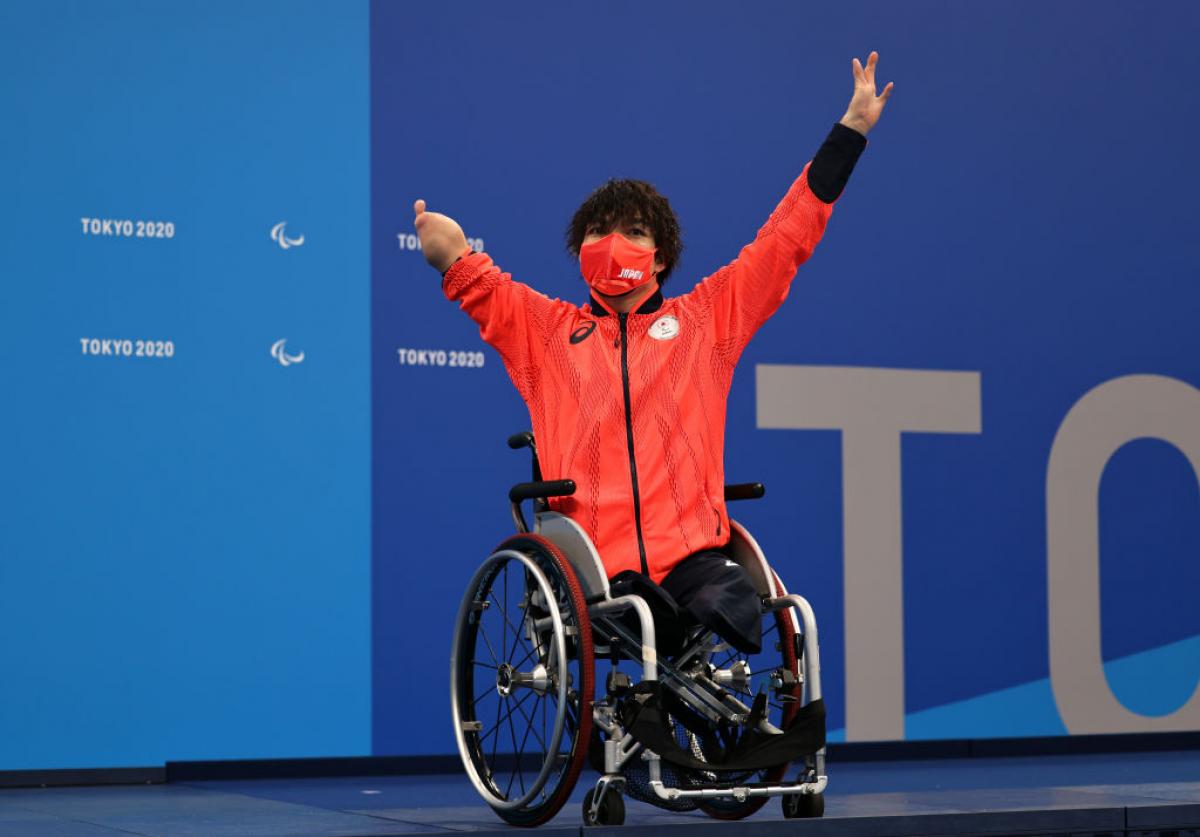 A man in a wheelchair with the uniform of Japan on a podium at the Tokyo 2020 Paralympic Games