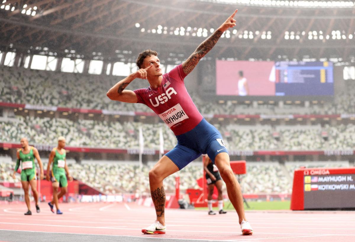 An athlete pointing towards the sky with his both hands in celebration.