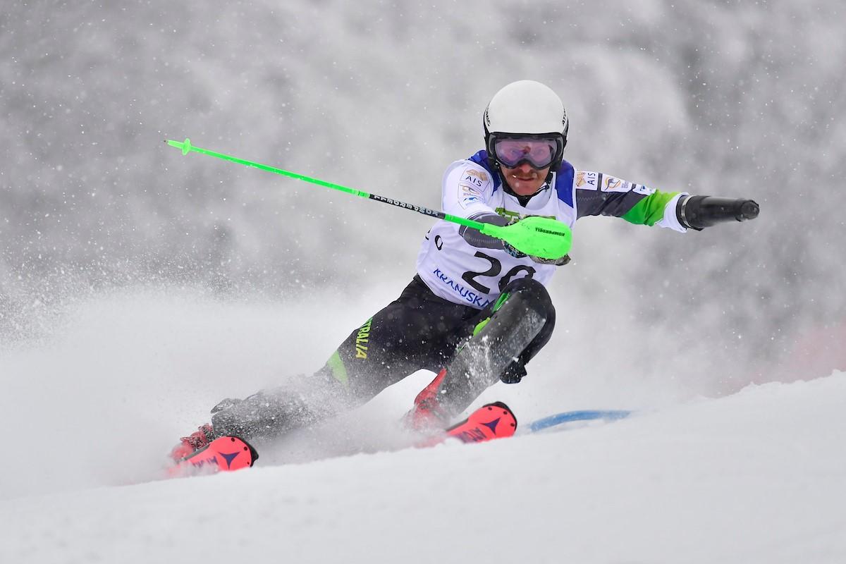 A man without an arm skiing in a Para alpine skiing competition