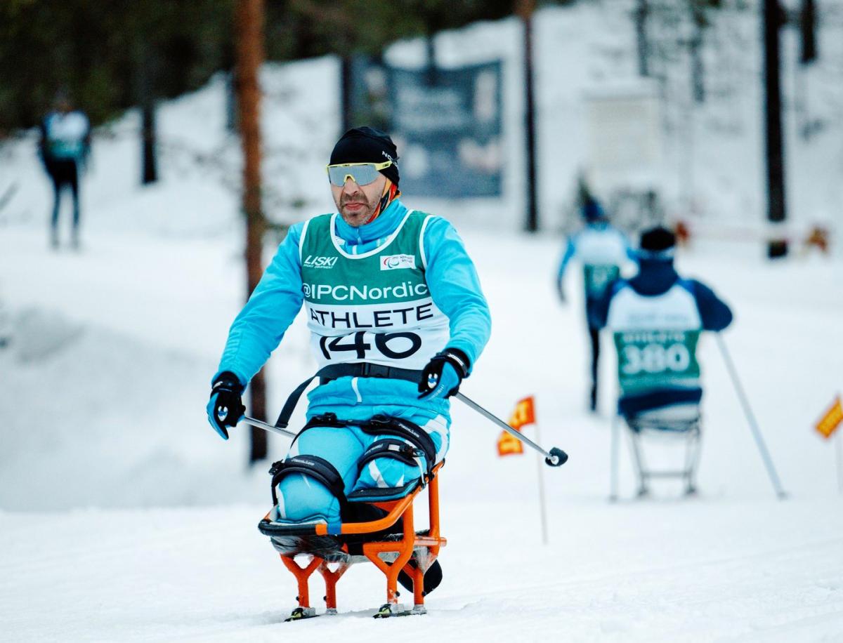 A male sit skier in a cross-country skiing competition
