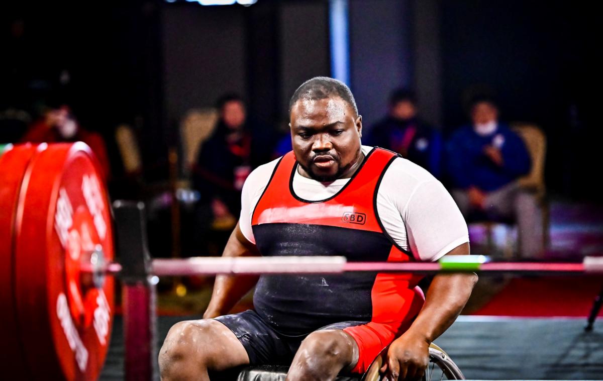 A man in a wheelchair in front of the bench concentrating before the lift