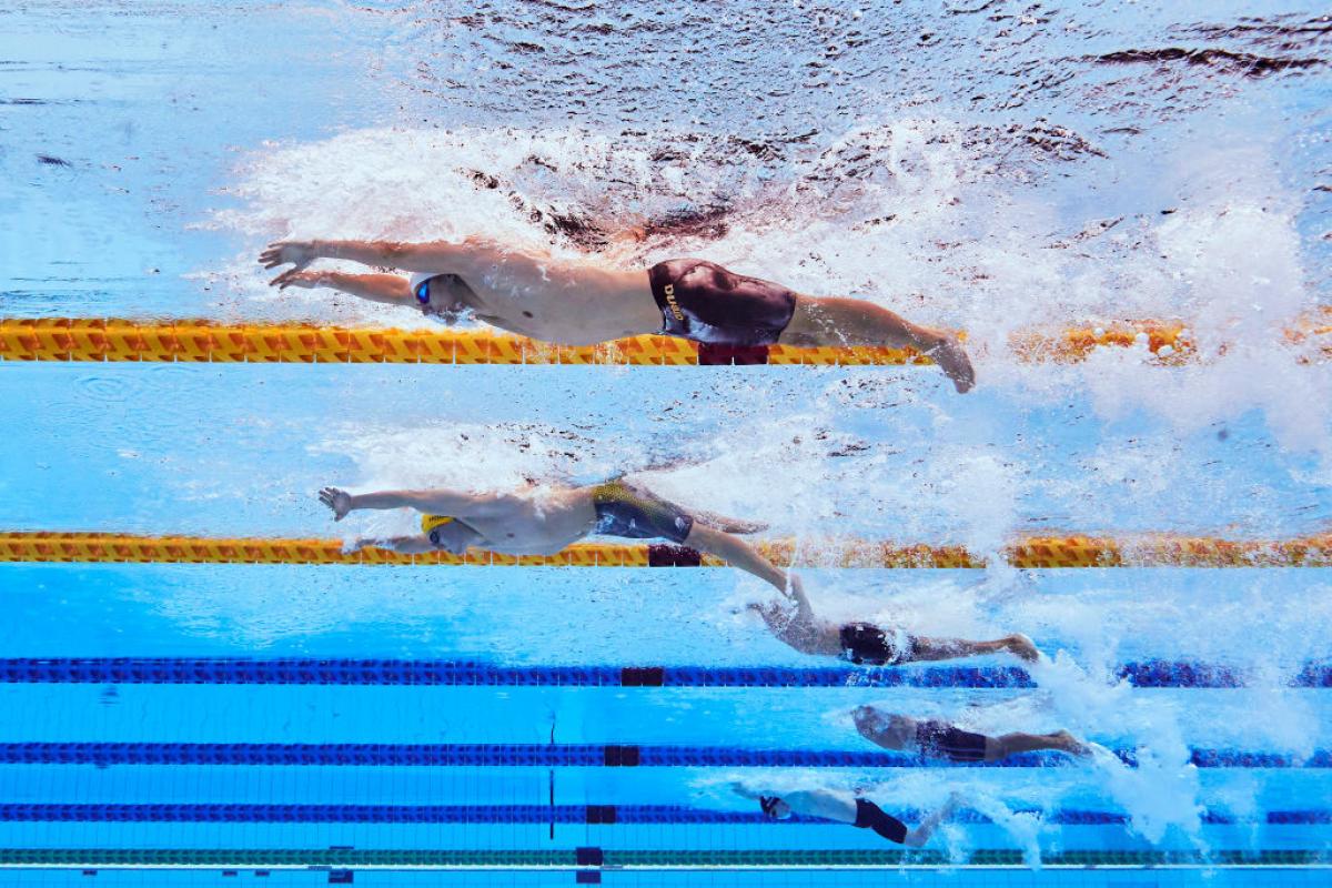 And underwater image of five men with disabilities in a swimming pool