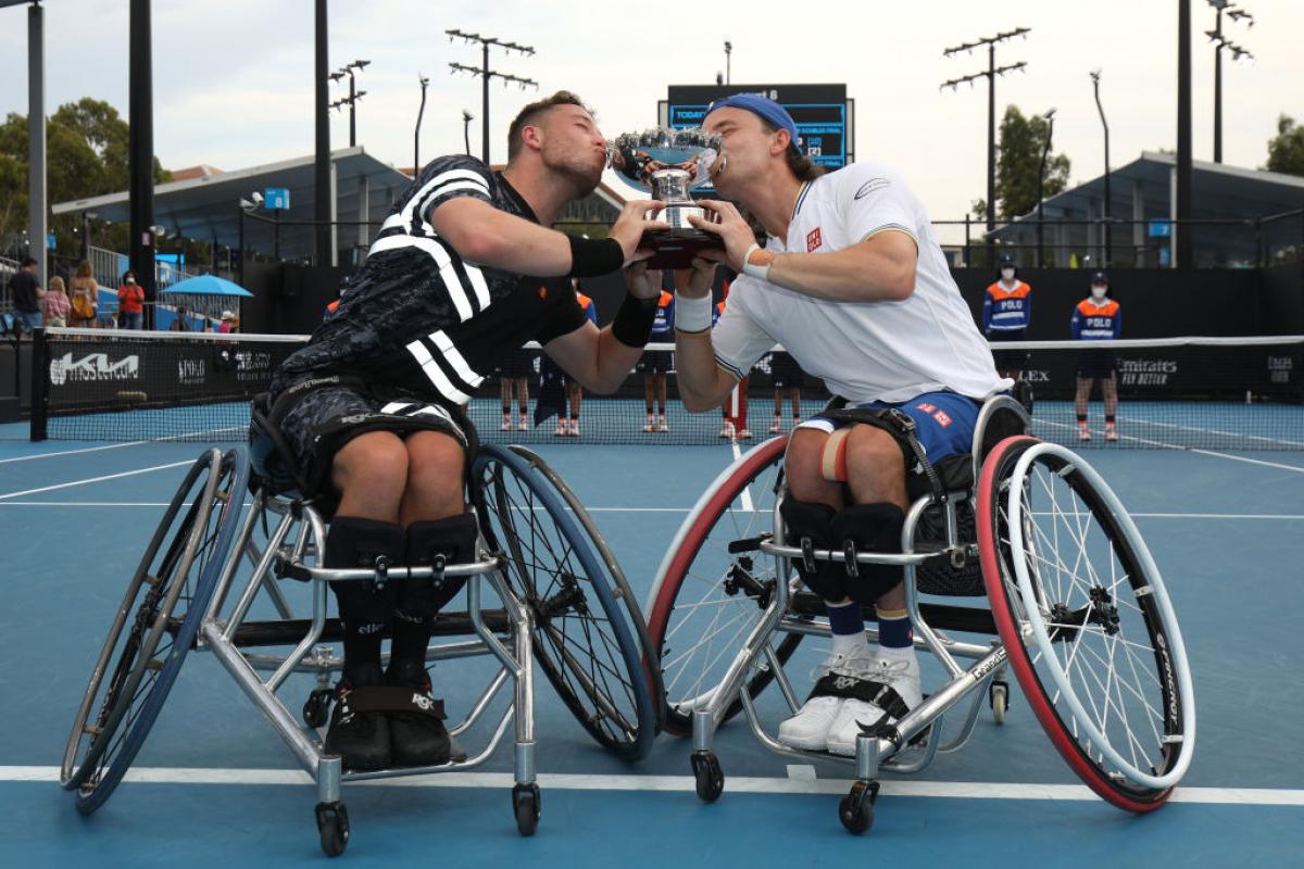 Alfie Hewett and Gordon Reid of Great Britain kiss the trophy after their victory in the men's Wheelchair Doubles final against Gustavo Fernandez of Argentina and Shingo Kunieda of Japan at the Australian Open.
