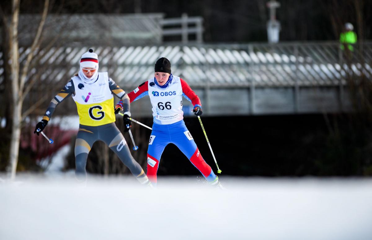 A female cross-country skier following her female guide