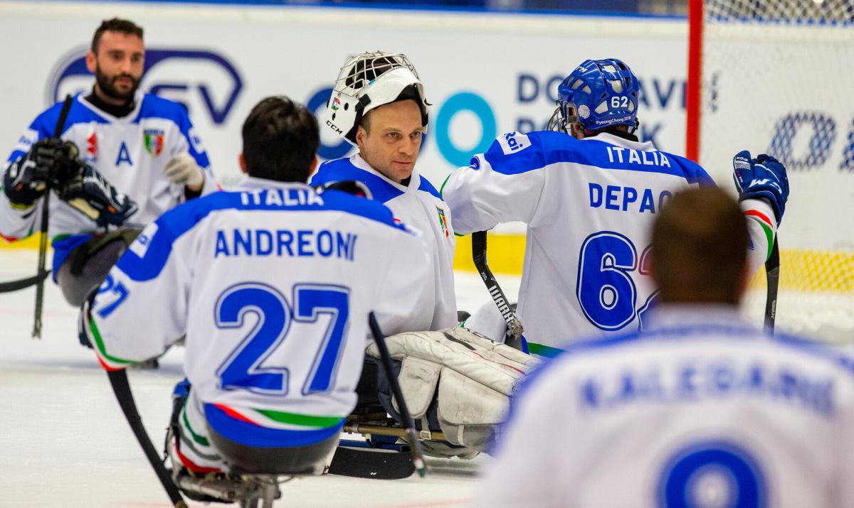 A goalie congratulated by his teammates on the ice