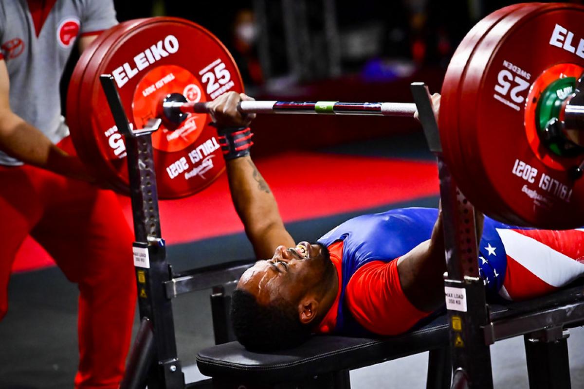 A man lifting a bar on a bench press