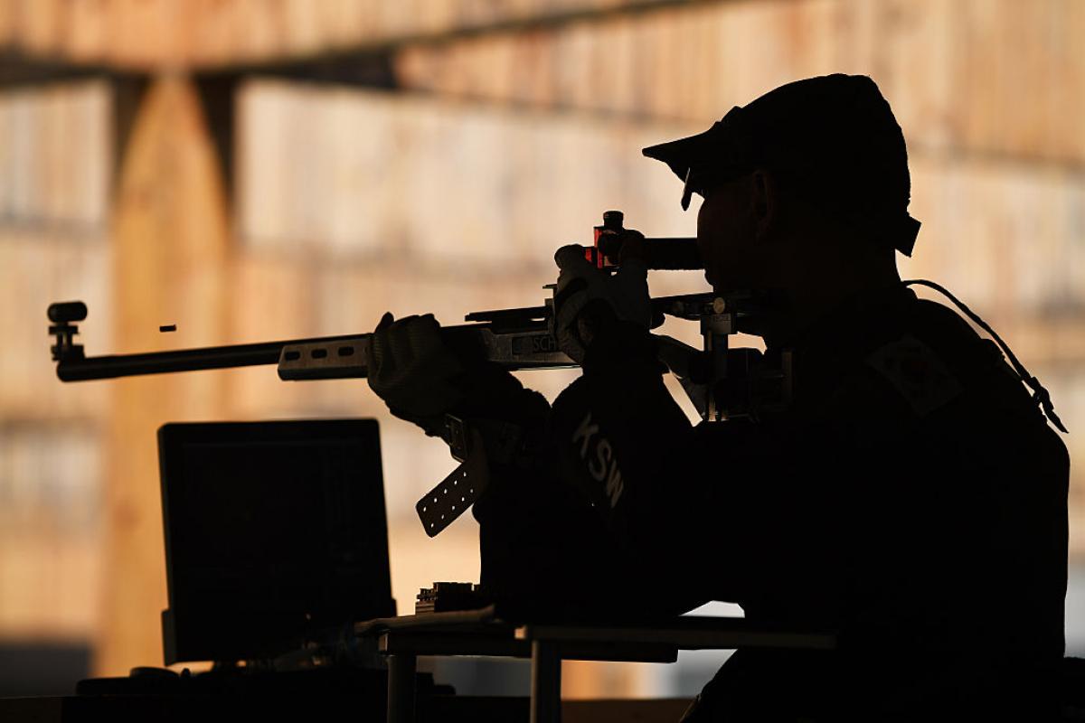 A male shooter with a rifle in a shooting range