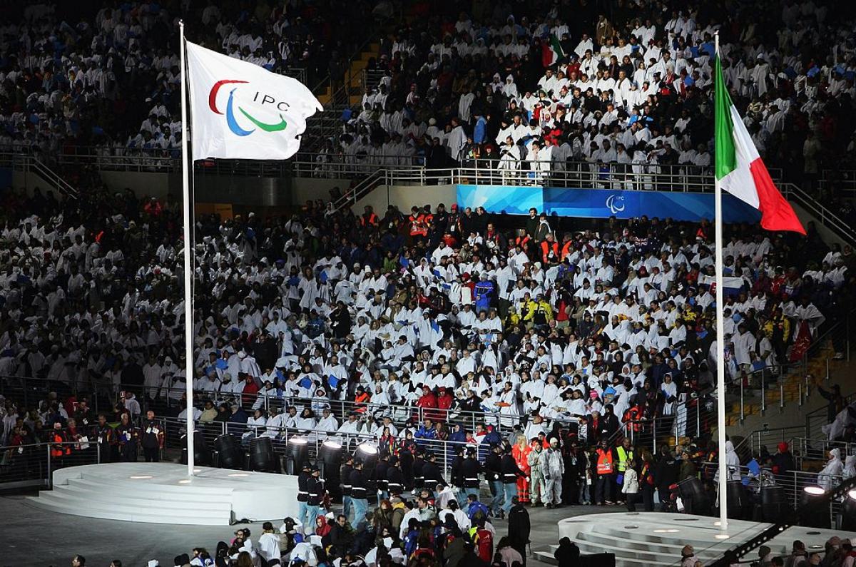 The International Paralympic Committee flag and the Italian national flag fly side by side during the Opening Ceremony of the Turin 2006 Paralympic Winter Games.