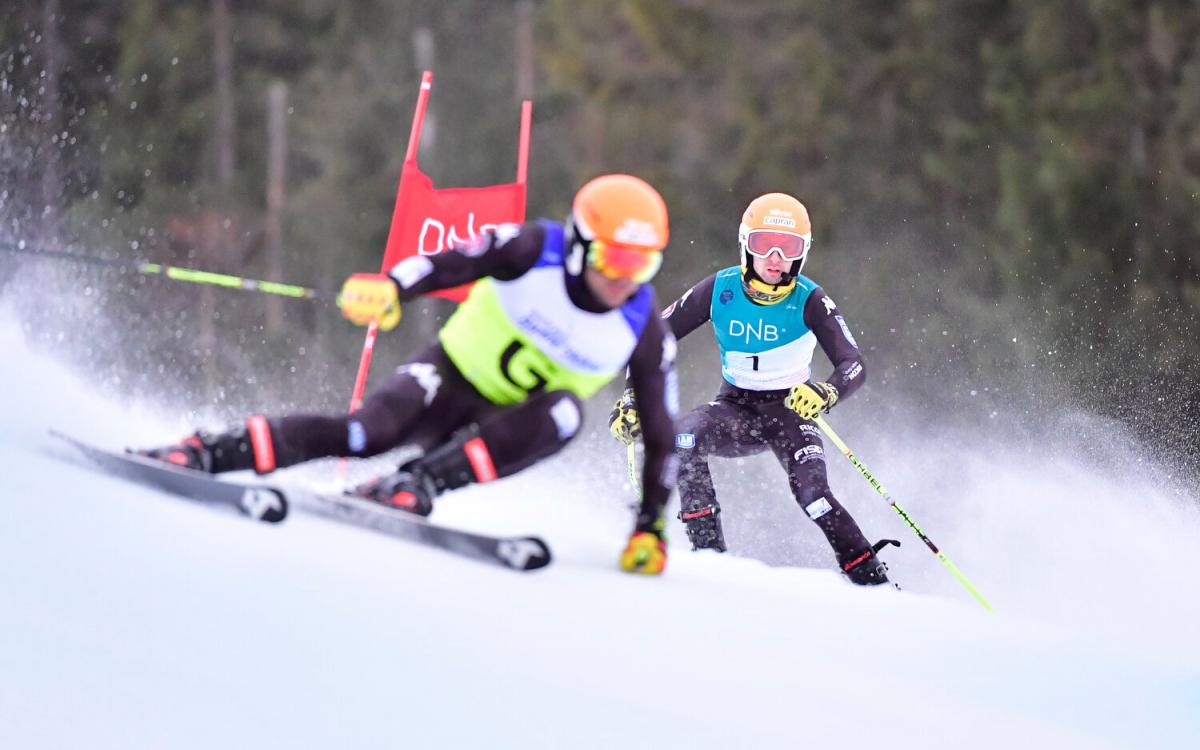 A man skiing with a microphone behind his guide.