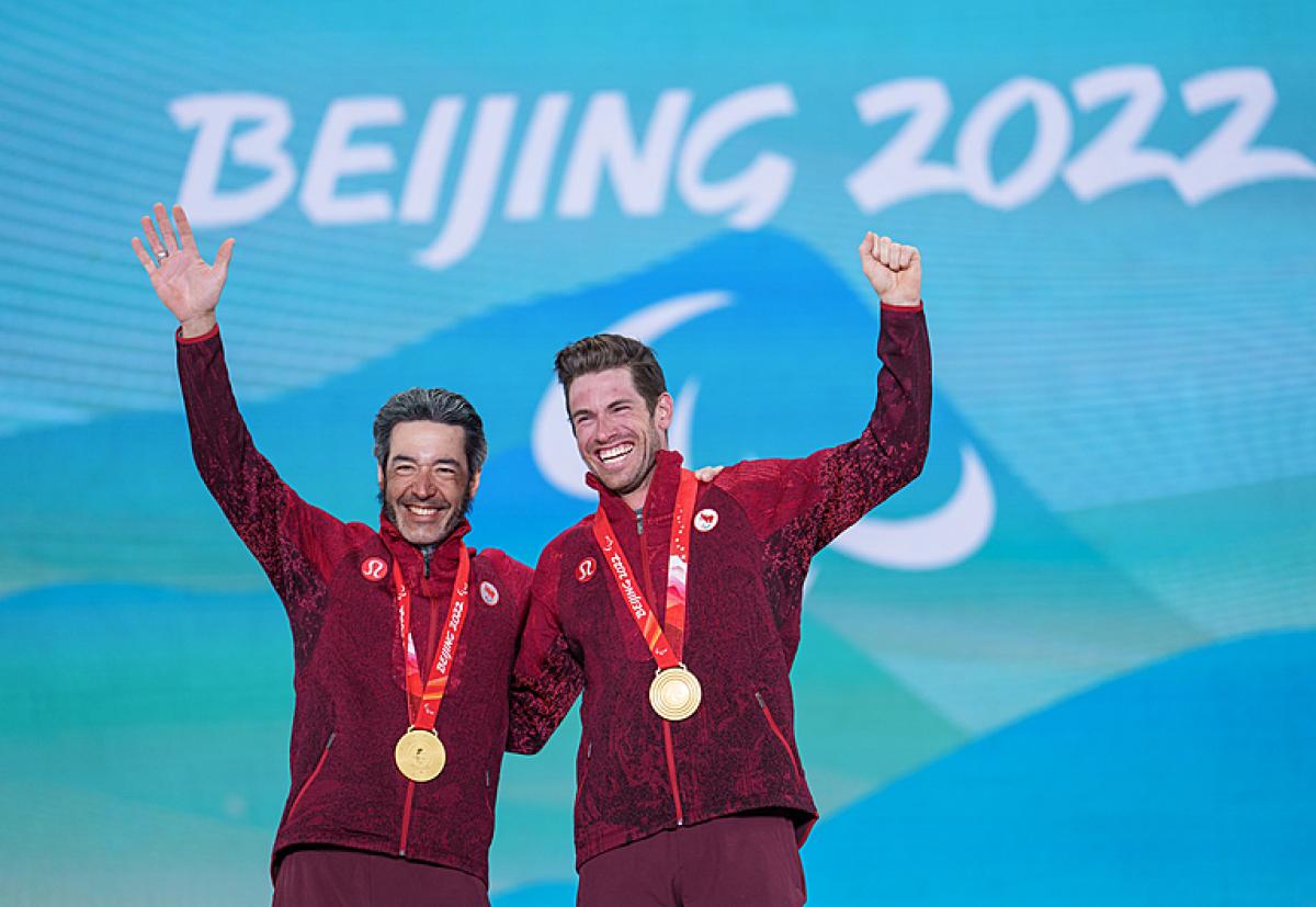 Brian Brian McKeever and Guide Graham Kennedy smile and wave after receiving their gold medals at Beijing 2022