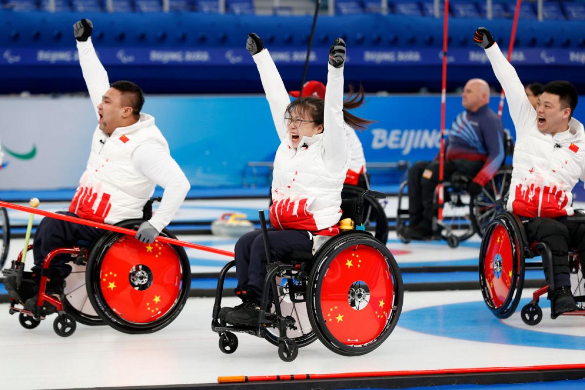 Chinese wheelchair curlers cheers with their arms in the airGett