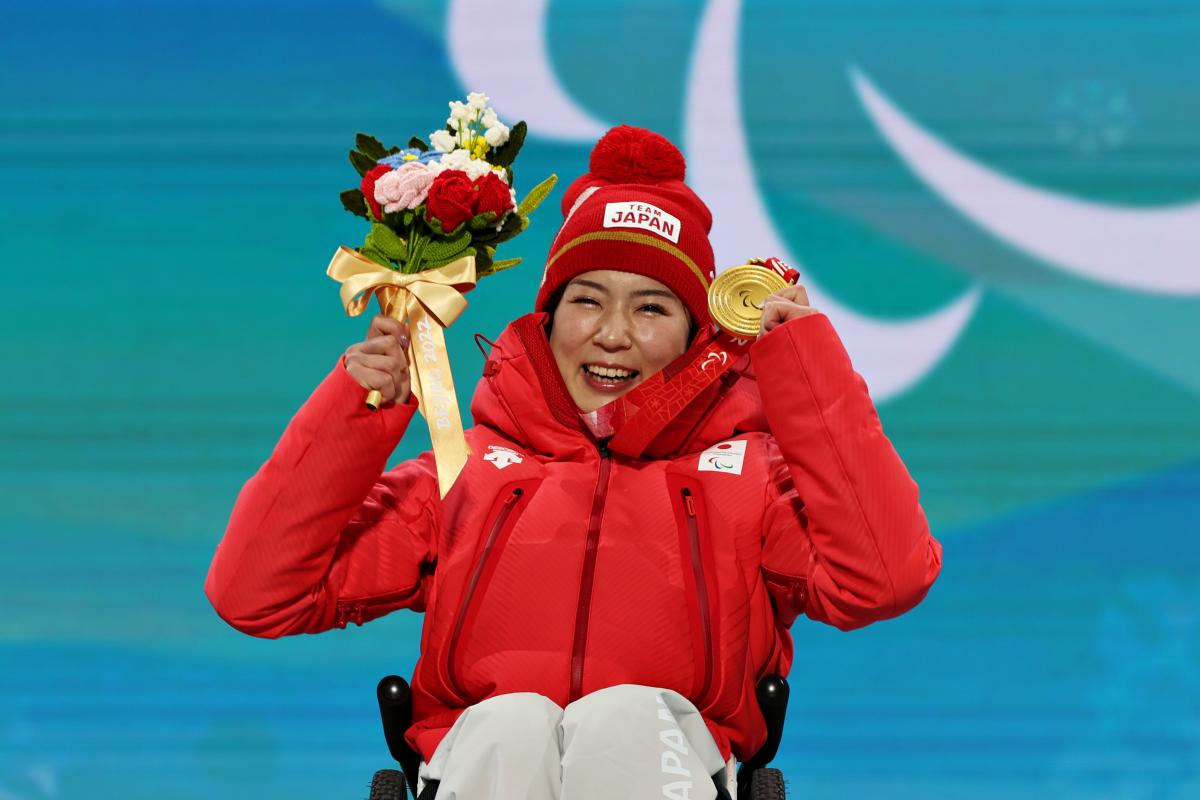 Japanese sit-skier Momoka Muraoka celebrates with her gold medal 