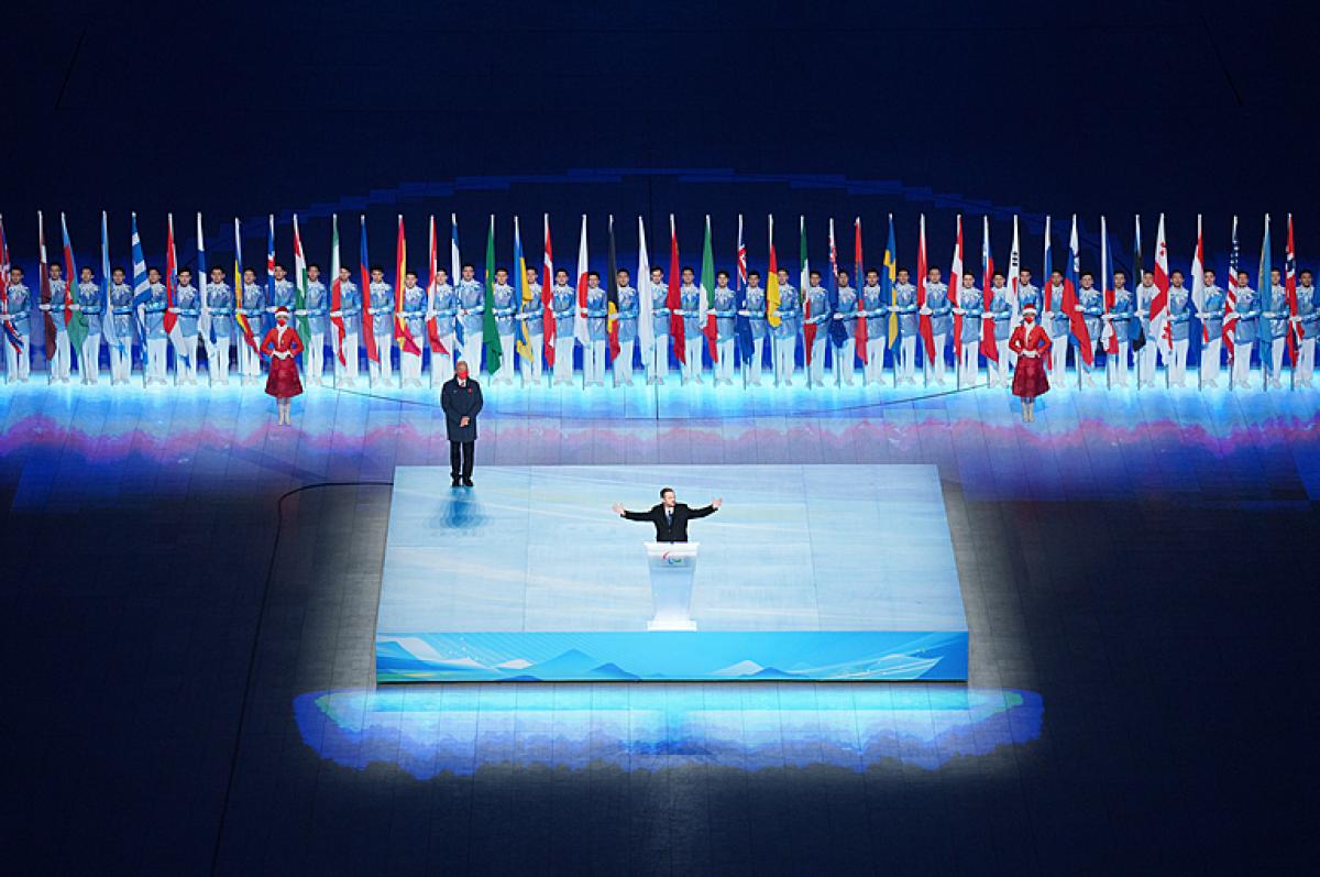 Andrew Parsons is pictured with his arms wide open while speaking during the closing ceremony of Beijing 2022