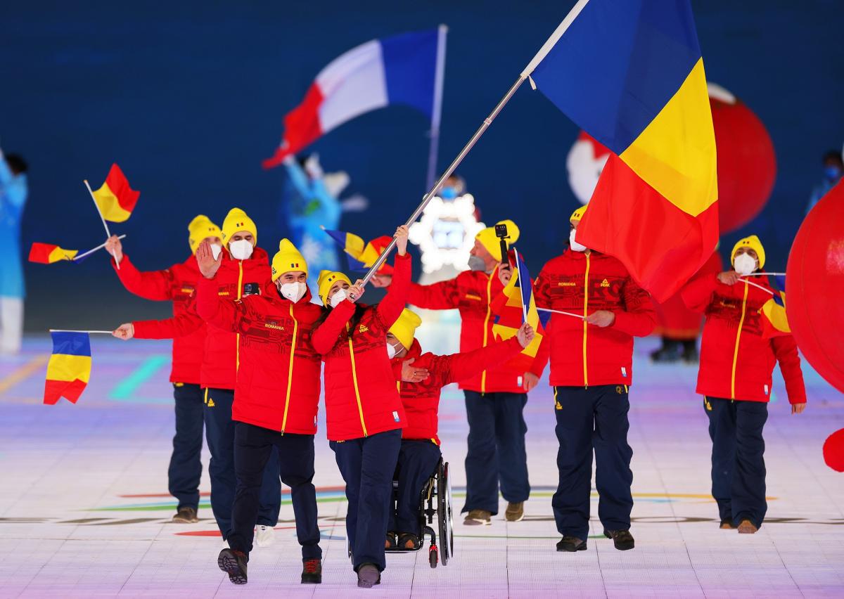 Laura Valeanu and Mihaita Papara carry the Romanian flag at the Opening Ceremony of Beijing 2022