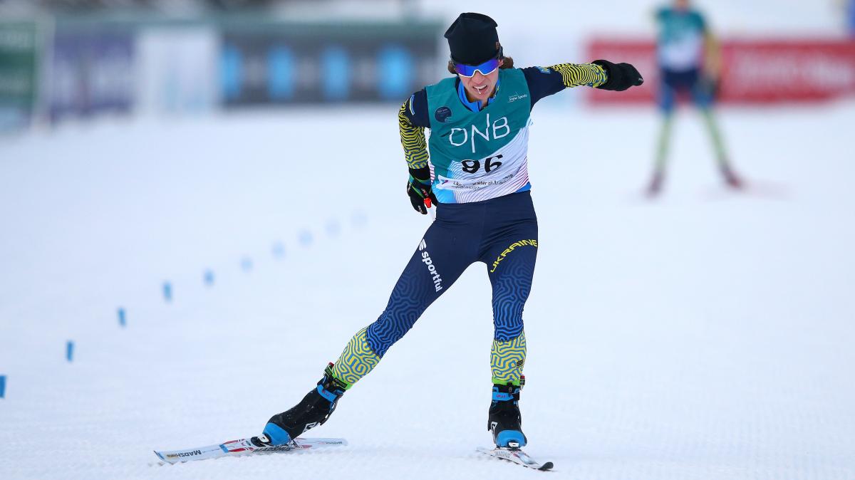 A female athlete ski's on a flat circuit with her goggles on.
