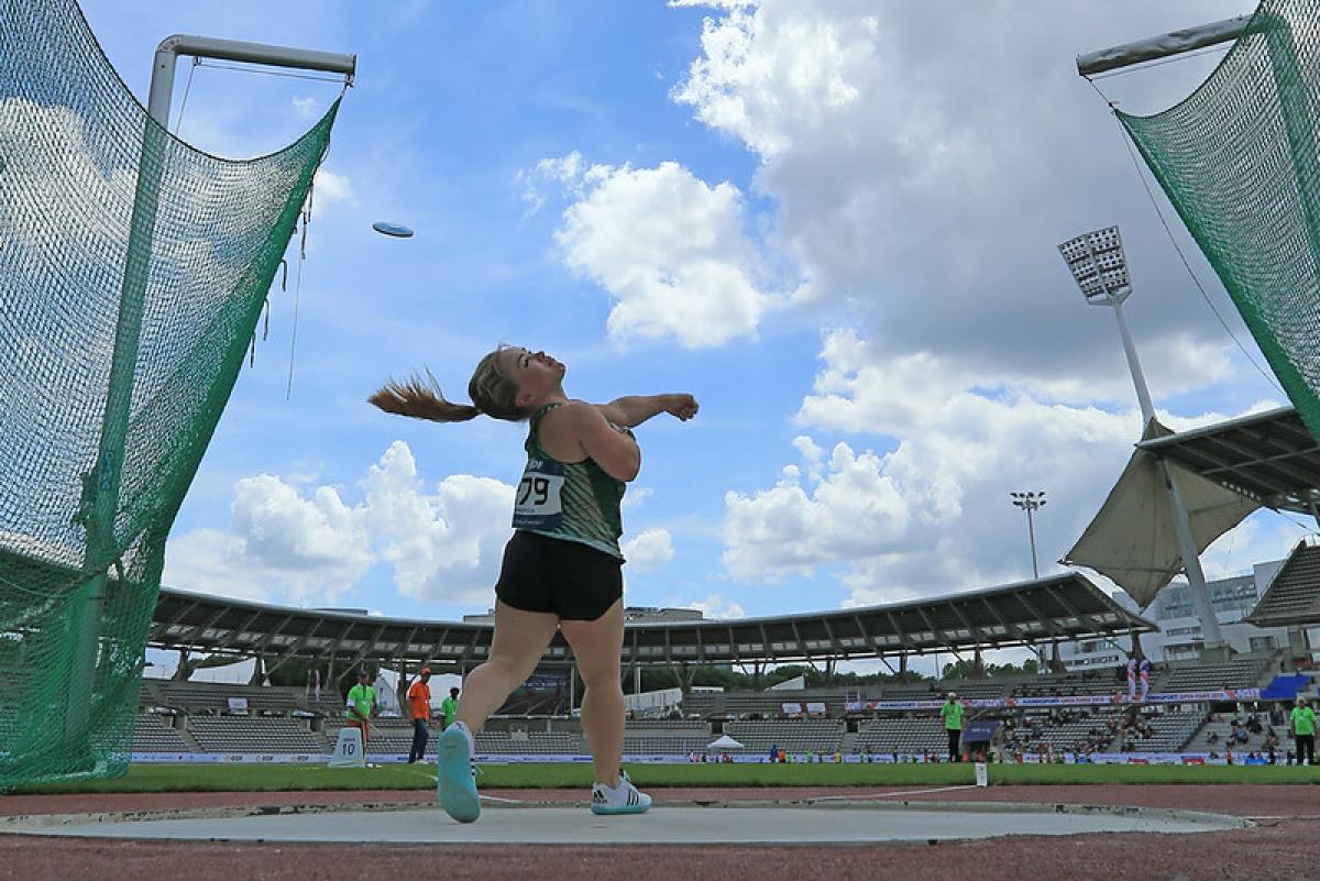 Image of a female Para Athletics in competition throwing a discus