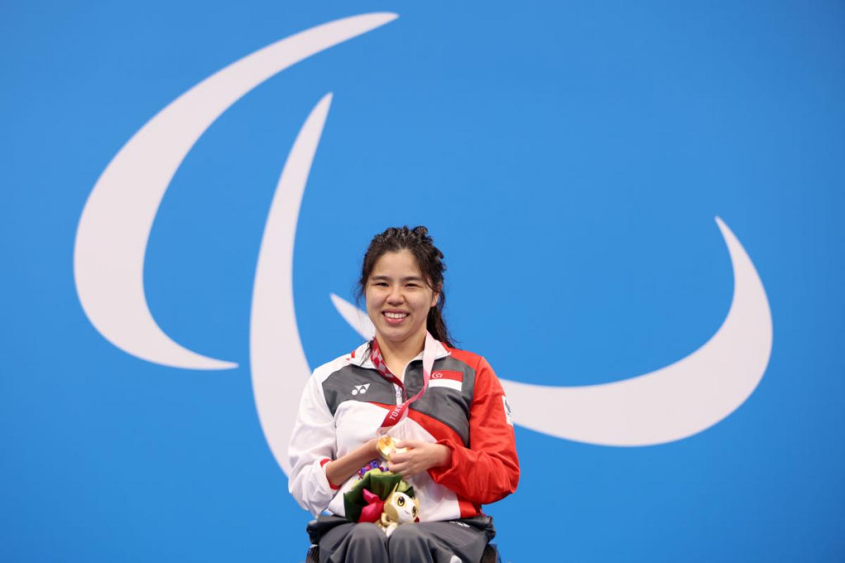 Image of a female para swimmer in the podium after she grabbed gold