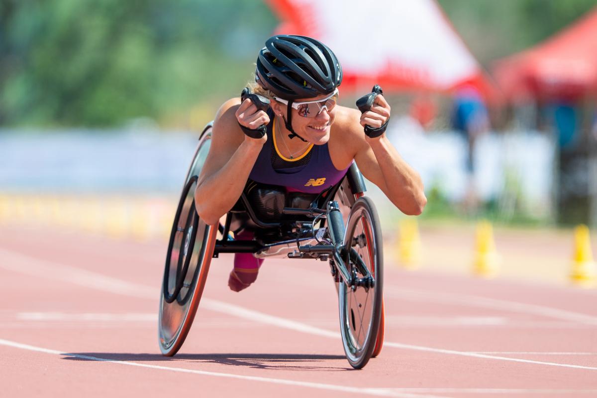 A female wheelchair racer celebrating on an athletics track