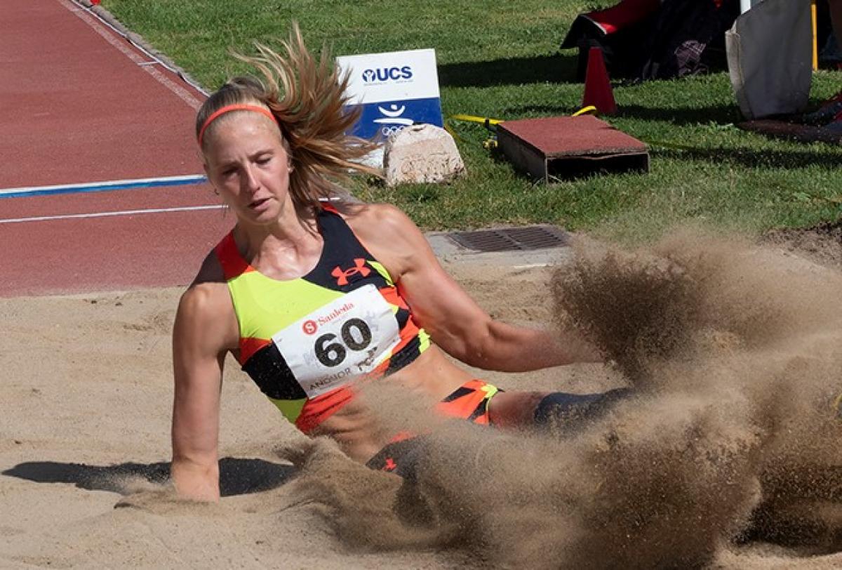 A woman landing in a sand box in a long jump competition