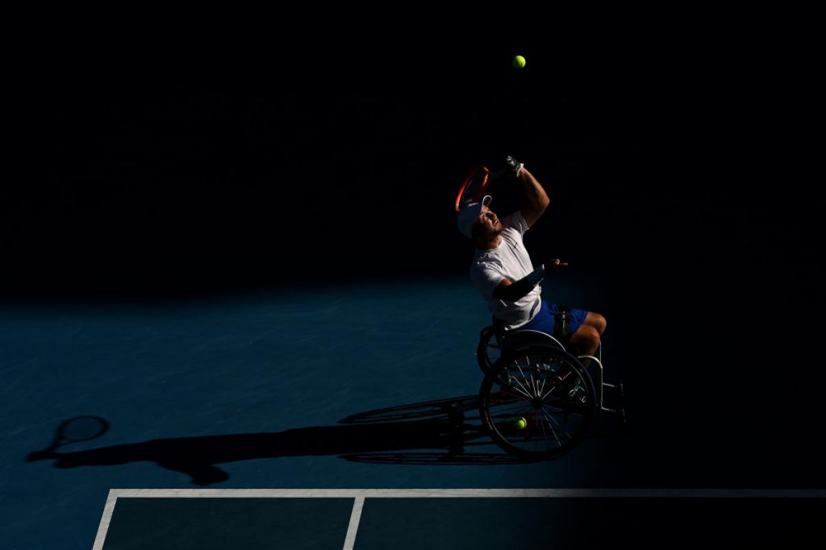 Dutch player Sam Schroder casts a shadow as he serves in the Australian Open final against Australia's Dylan Alcott.