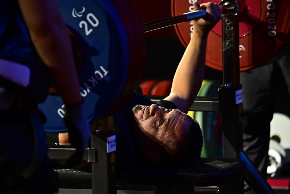 A man preparing to lift a bar on a bench press