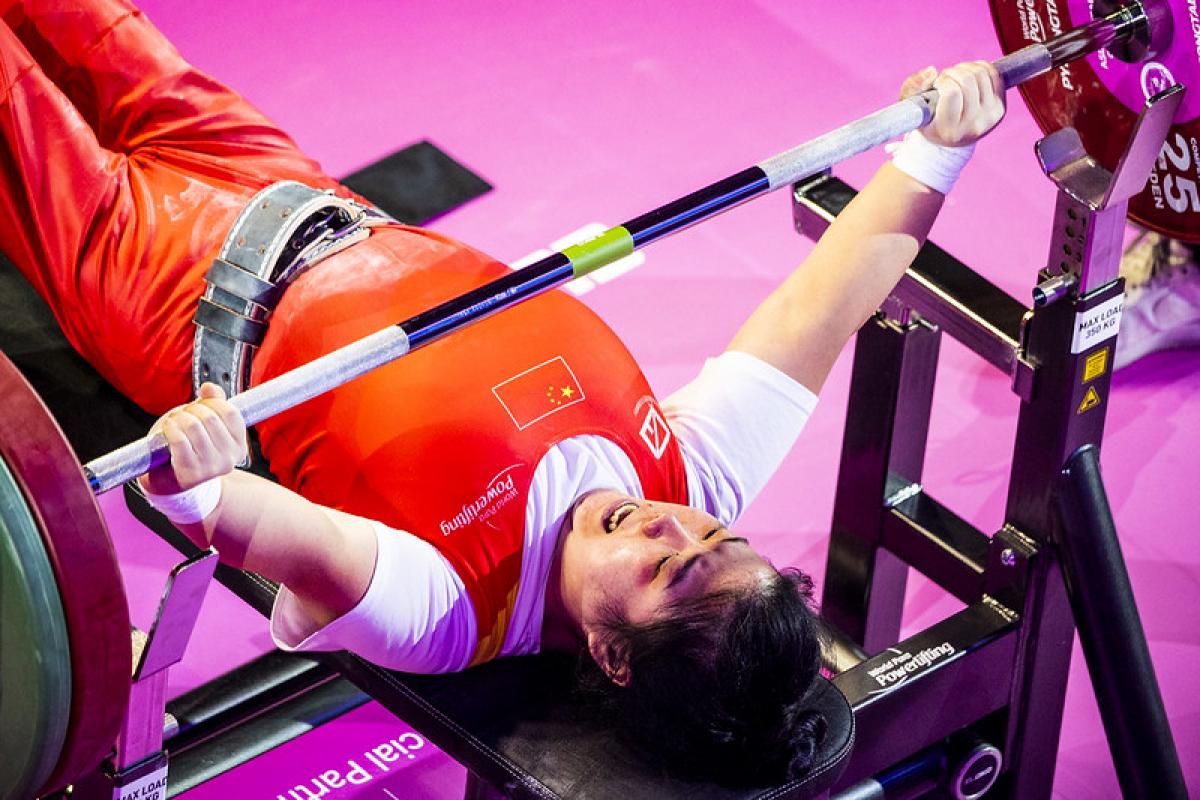 A female Para powerlifter lifting the bar