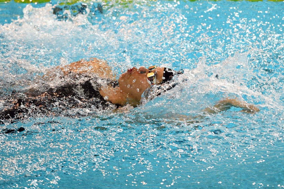 A female athlete swimming backstroke in a pool