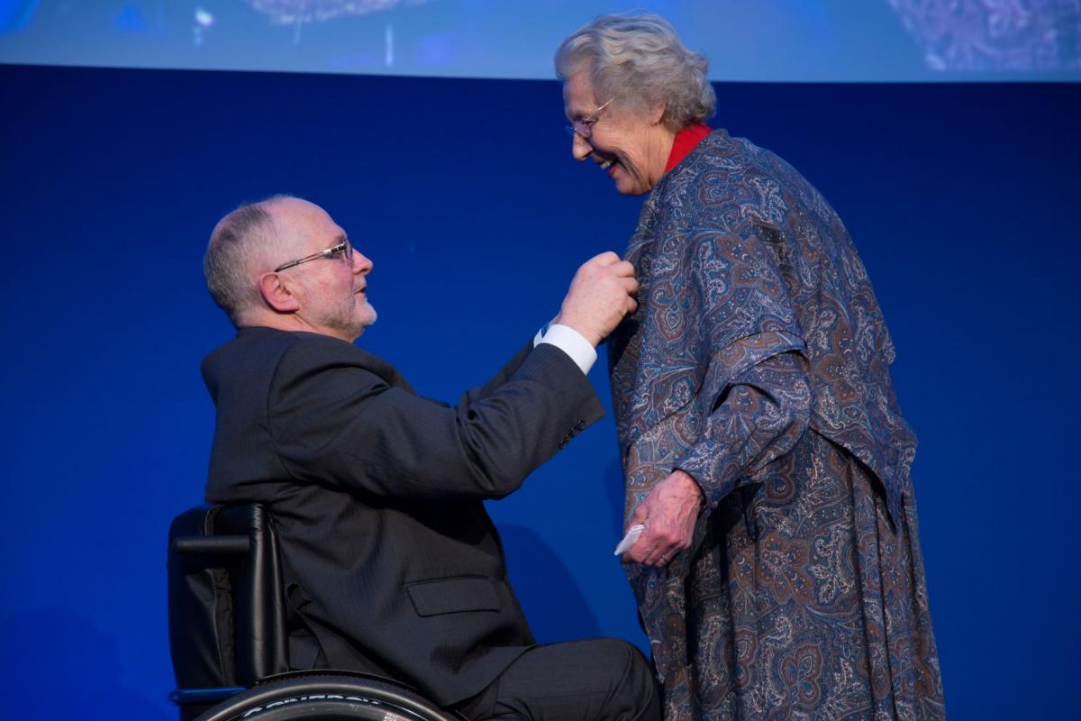 Sir Philip Craven presents the Paralympic Order to a smiling Jonquil Solt.