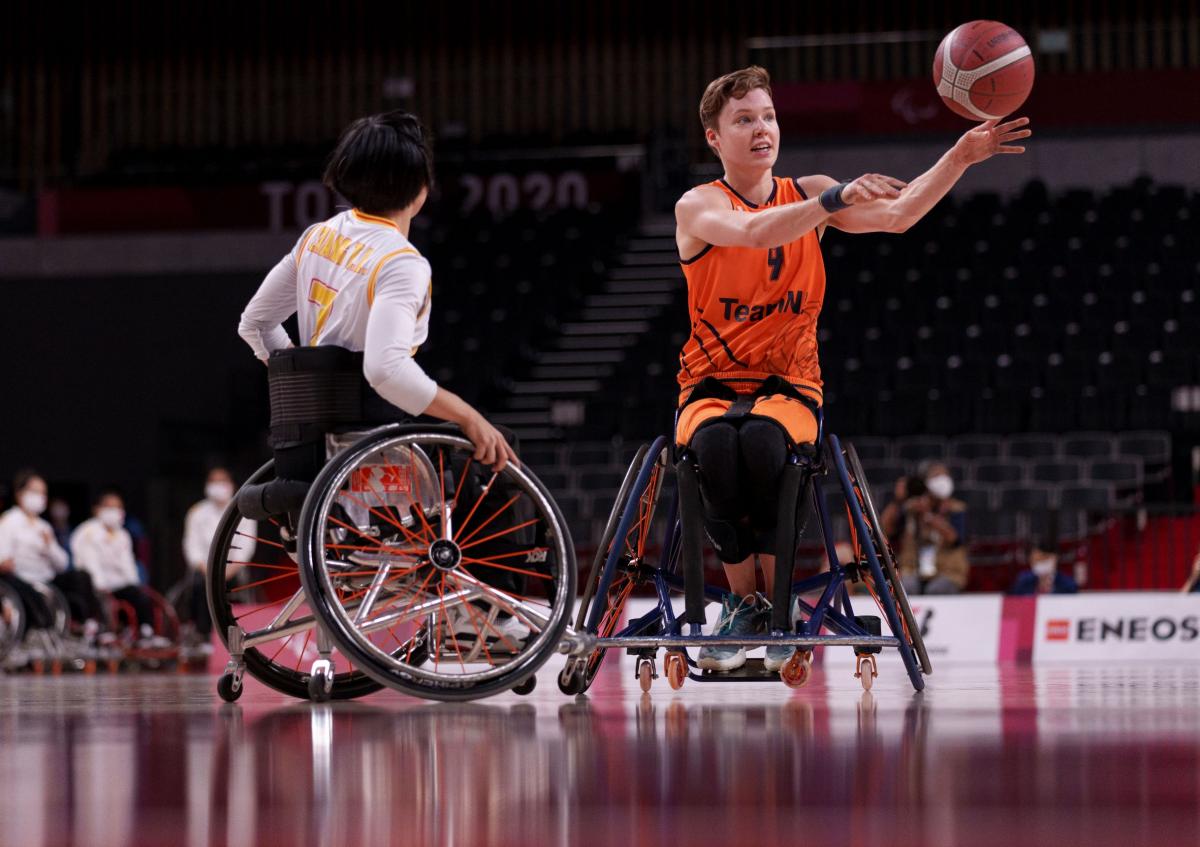 Bo Kramer makes a pass during the gold medal match at Tokyo 2020 as a Chinese player faces her.